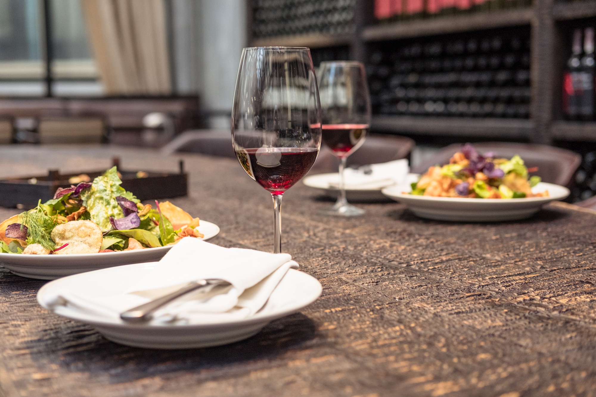 delicious salad with wine on rustic wooden table for romantic dinner at luxury restaurant